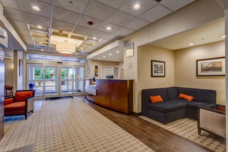 Lobby area with seating, front desk, and doors