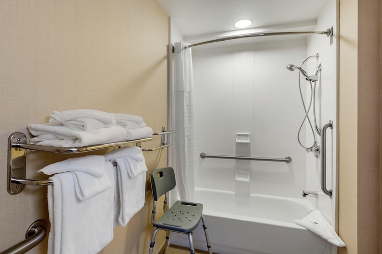 Accessible bathtub and shower with grab bars and chair